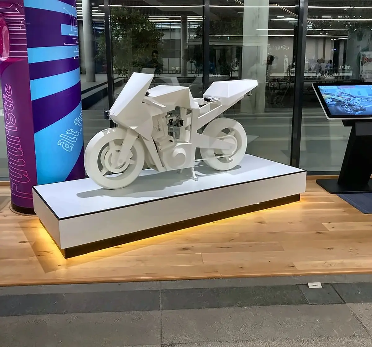 White sculptural motorcycle showpiece on a lit plinth